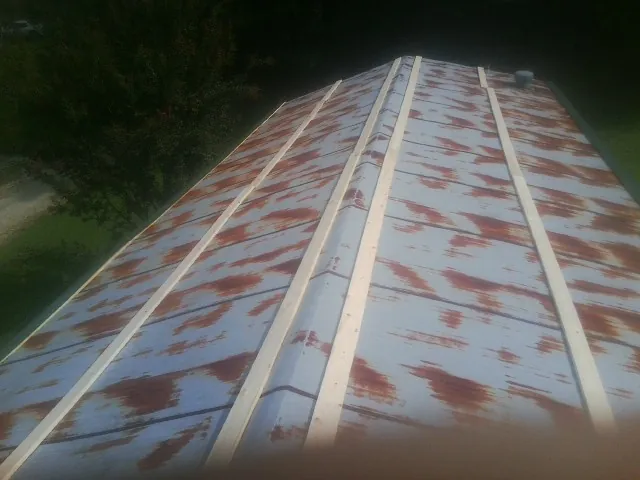 Rusted metal roof panels with new wood purlins before replacement — Storm Damage Roof Repair in College Park by Roofing Brothers