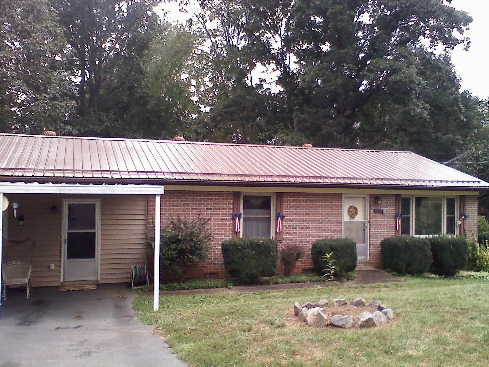 Bronze metal roof and carport on a brick ranch home — Roof Repair work by our crew in College Park