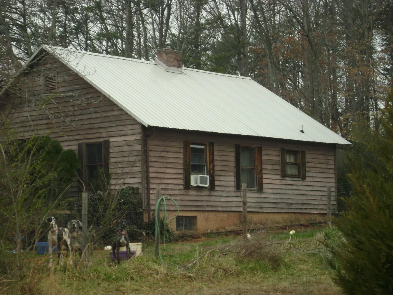White metal roof on an old wood sided farmhouse, from a Metal Roof Installation job in College Park